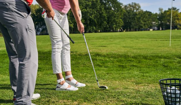 instructor-teaching-beginner-golfer-get-into-proper-golf-stance